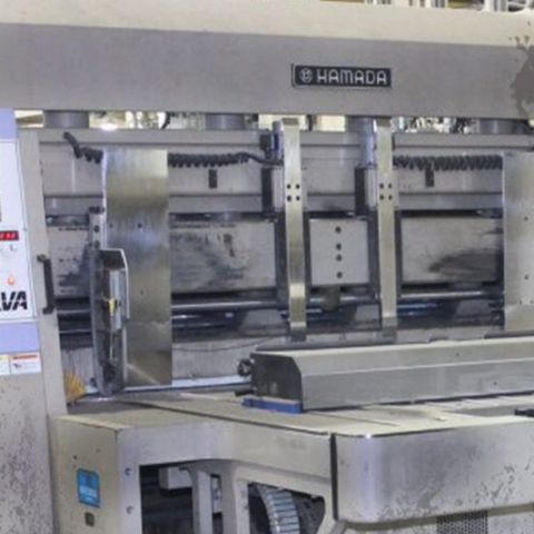 A corrugated press before cleaning: dust and residue over the frame, guards and base