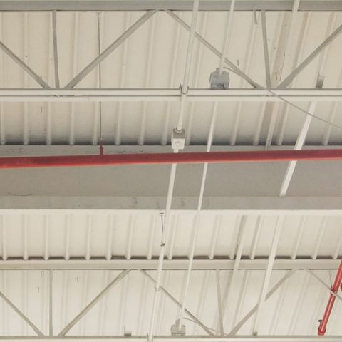 The same ceiling after Kelly cleaned it: deck, trusses and pipe clean and bright