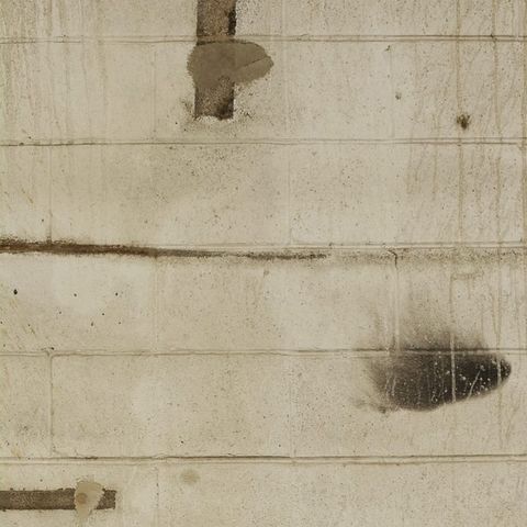 A block wall before painting: stains, scuffs and bare patches